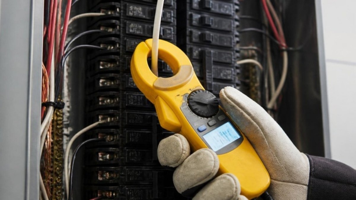 Ampe kìm kẹp vào dây điện để đo dòng trong tủ điện gia đình