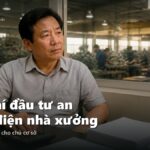 Chủ xưởng tính toán chi phí trong văn phòng nhìn ra nhà xưởng